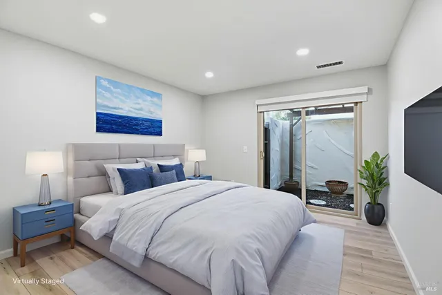 a spacious bedroom with a large bed and a potted plant