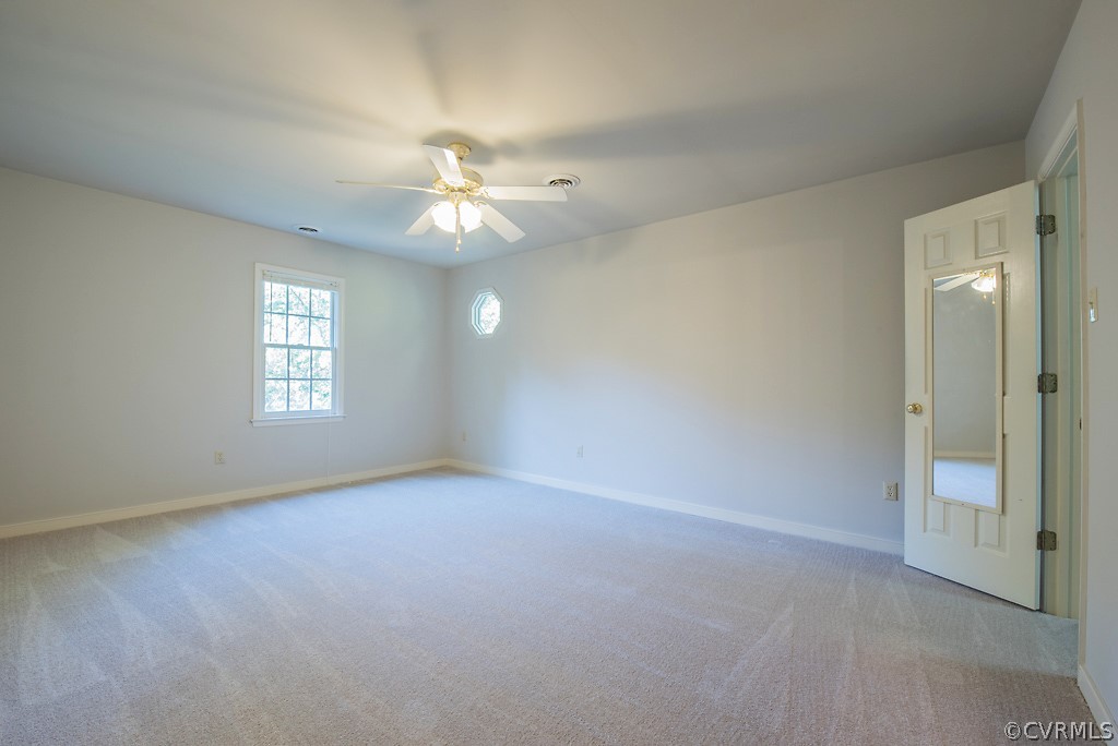 10400 White Rabbit Road North Chesterfield, VA 23235 - Photo 31 of 50 an empty room with a chandelier fan and windows