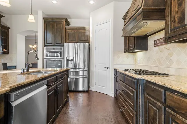 a kitchen with stainless steel appliances granite countertop a stove and a sink