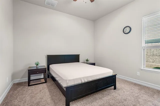 a large bed sitting in a bedroom next to a window