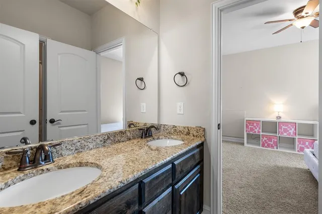 a bathroom with a granite countertop sink a mirror and a shower