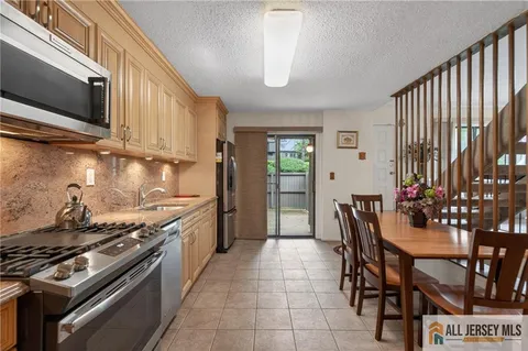 a kitchen with stainless steel appliances stove top oven table and chairs