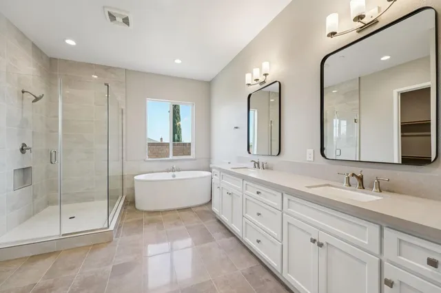 a spacious bathroom with a double vanity sink mirror double and bathtub