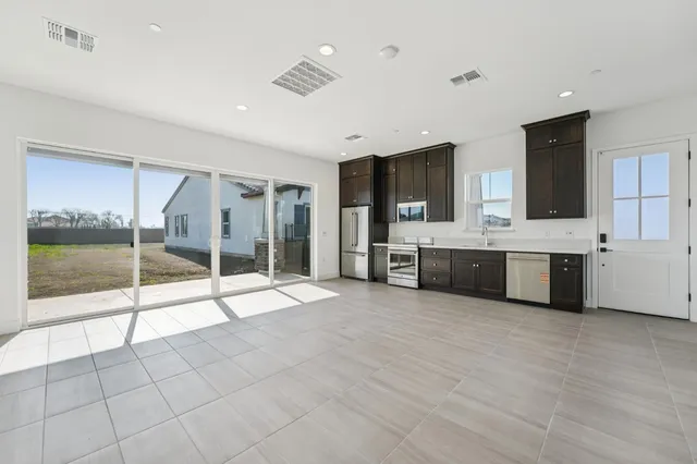 a large white room with a large window and kitchen view