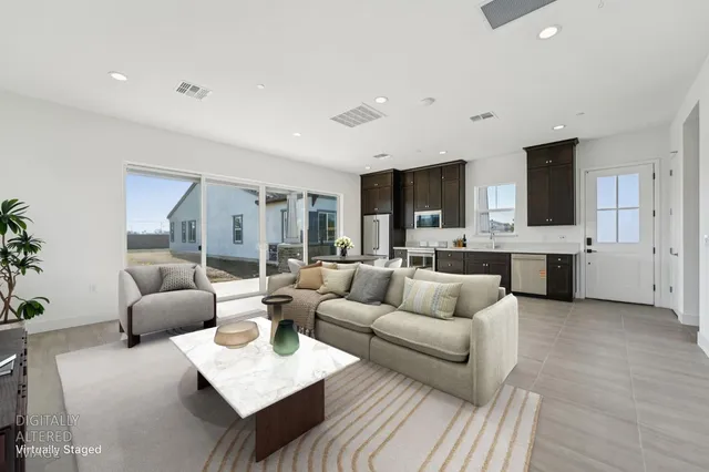 a living room with furniture and view of kitchen