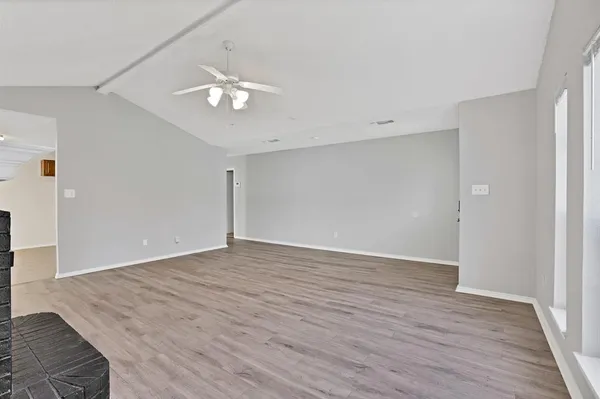 a view of an empty room with wooden floor