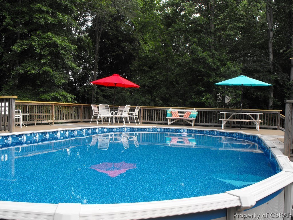 207 Windsor Road Dutton, VA 23050 - Photo 36 of 38 a view of a swimming pool with a table and chairs under an umbrella