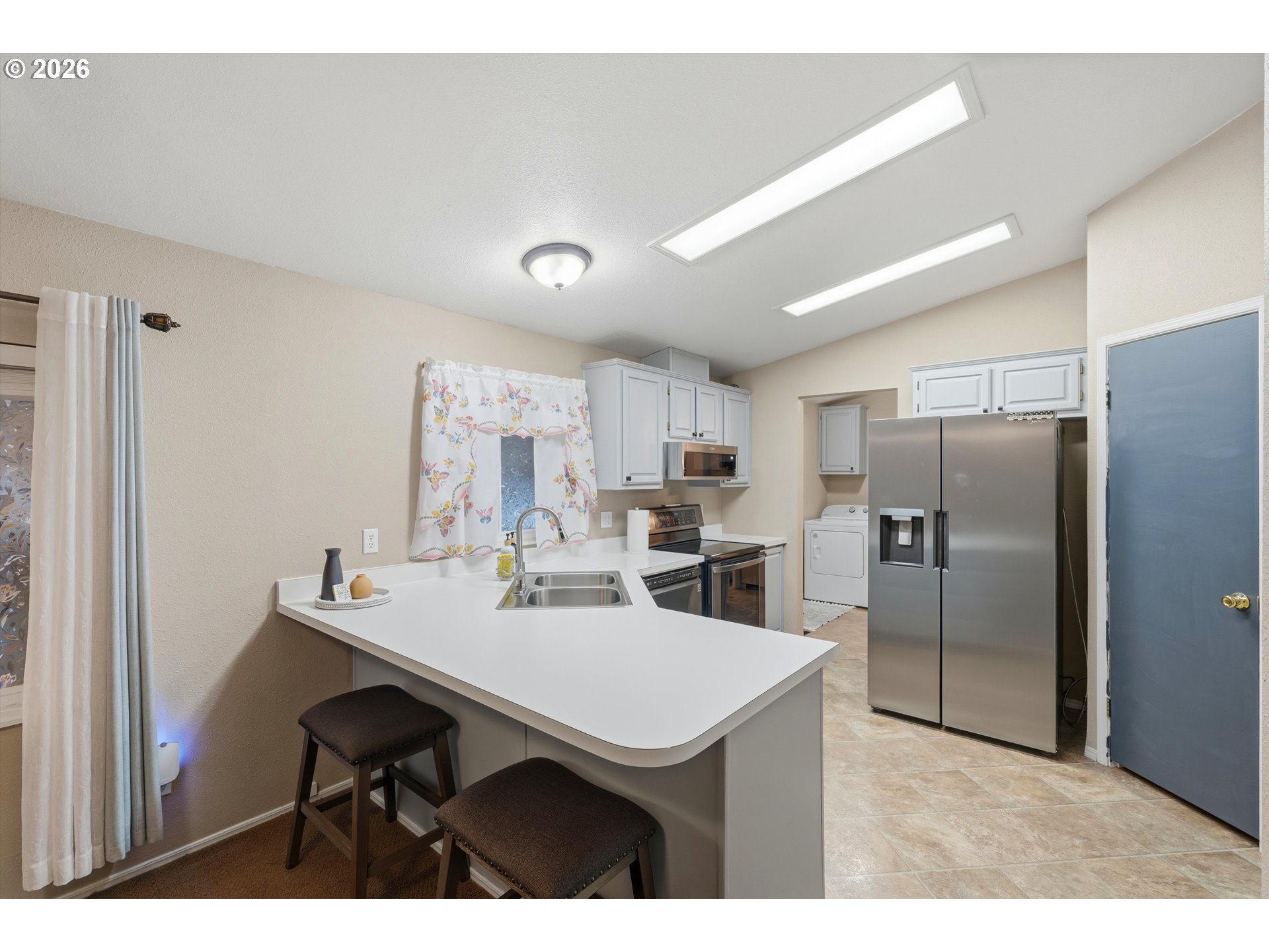 369 Gun Club Road, Unit 88 Woodland, WA 98674 - Photo 8 of 17 a kitchen with kitchen island a refrigerator sink and cabinets