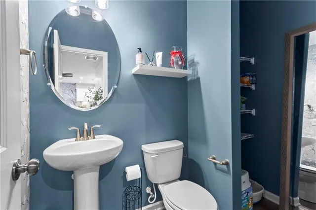 a bathroom with a toilet sink and mirror