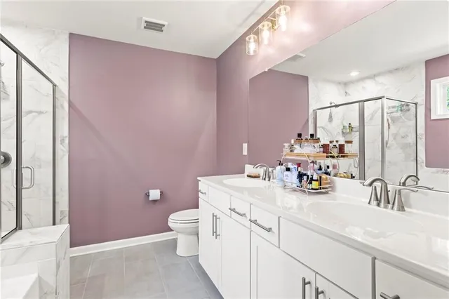 a bathroom with a sink a toilet a mirror and shower