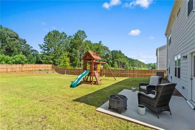 a view of a swimming pool with a patio and a yard