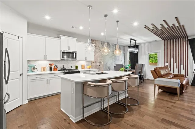 a kitchen with a sink a counter top space stainless steel appliances and cabinets