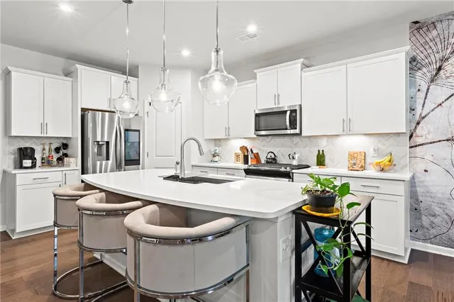 a kitchen with kitchen island a dining table and chairs