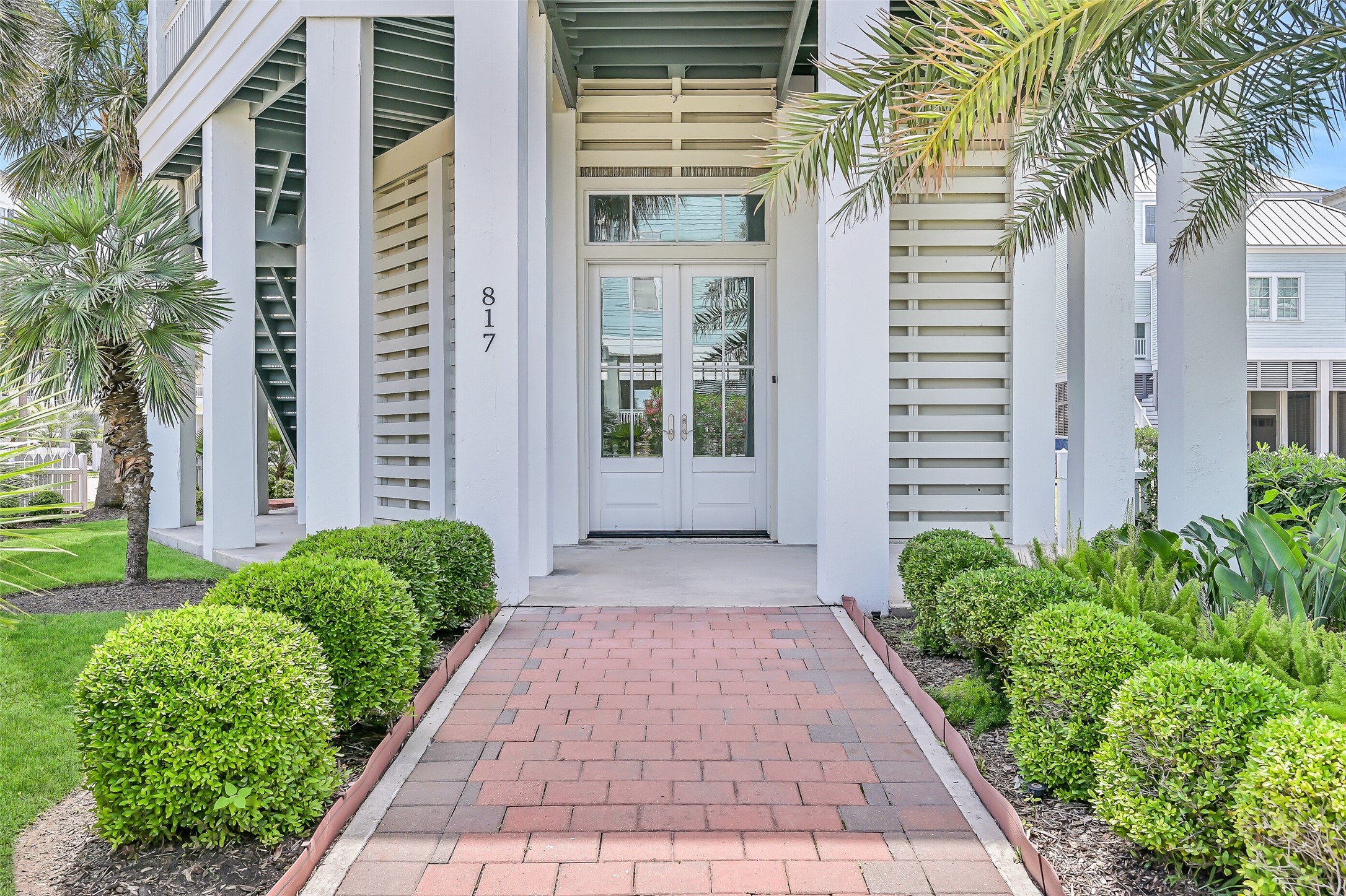 817 Positano Road Galveston, TX 77550 - Photo 9 of 50 Thoughtfully landscaped and beautifully maintained, the entrance sets the tone for the exceptional experience that awaits inside. Coastal elegance begins the moment you arrive.