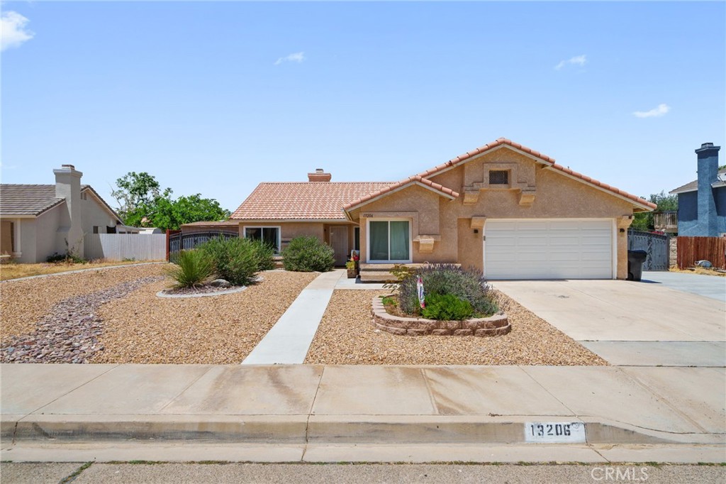 13206 Brant Road Victorville, CA 92392 - Photo 1 of 1 a front view of a house with a yard and garage