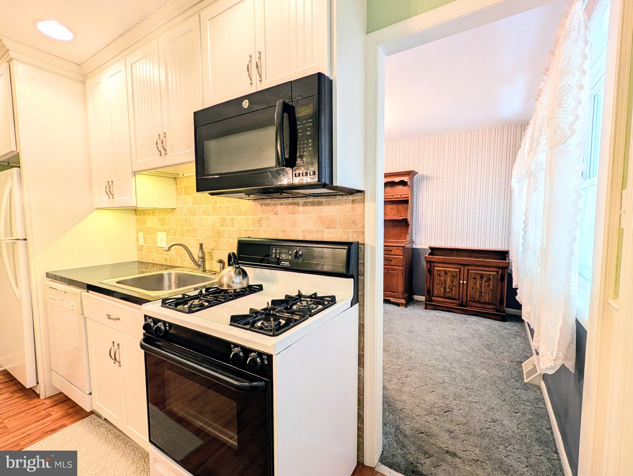 1439 Michigan Avenue Swarthmore, PA 19081 - Photo 38 of 54 a kitchen with stainless steel appliances a stove a microwave and a refrigerator