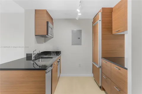 a kitchen with stainless steel appliances granite countertop a sink and a stove top oven