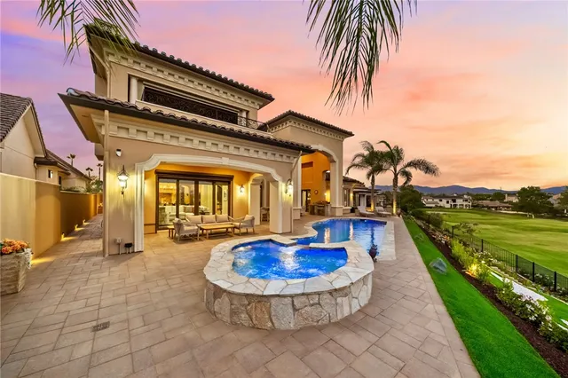 a living room with a table chairs and a chandelier