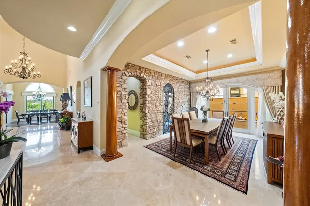 a living room with furniture a chandelier and a dining table with wooden floor