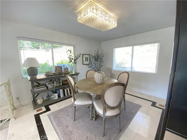 a kitchen with stainless steel appliances kitchen island granite countertop dining table chairs and a refrigerator