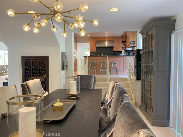 a view of a dining room with furniture a chandelier and wooden floor