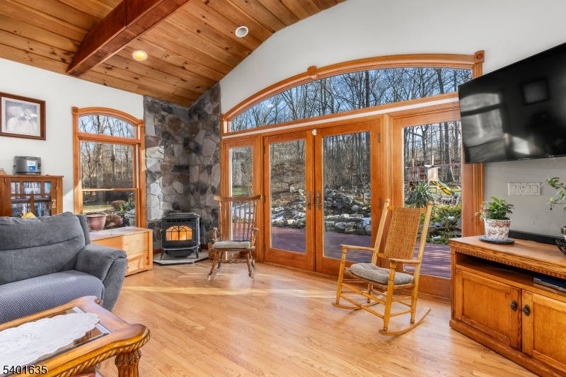 37 Ward Road Blairstown, NJ 07825 - Photo 12 of 28 a living room with furniture a flat screen tv and floor to ceiling window