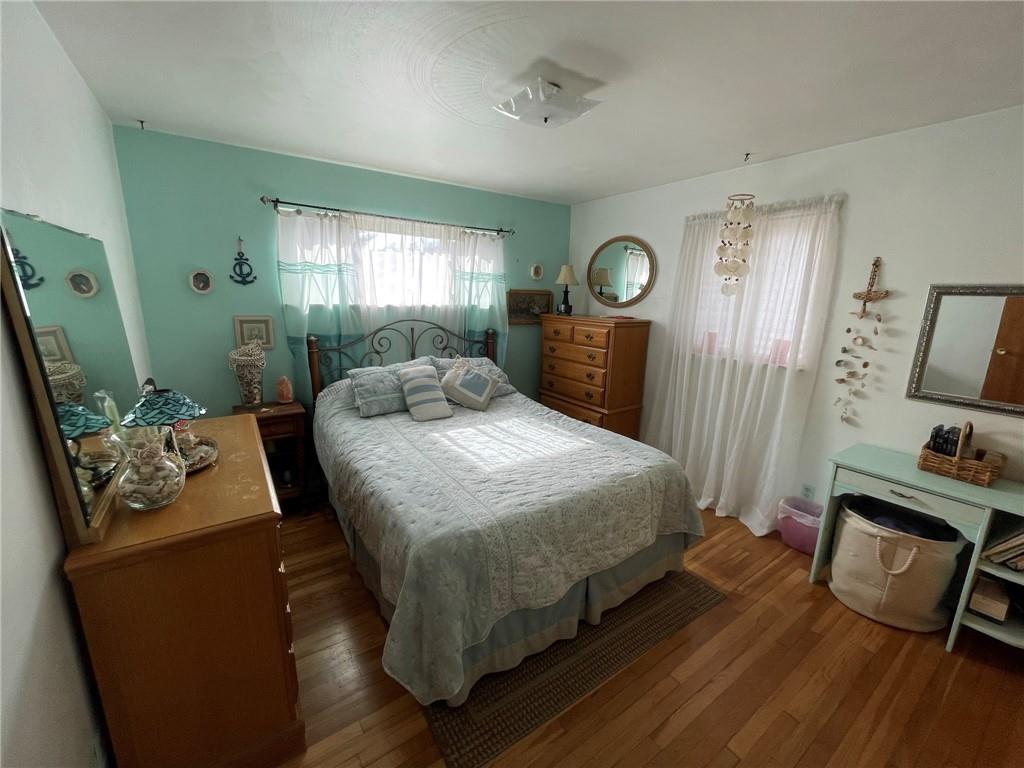 63 Locust Street McKees Rocks, PA 15136 - Photo 10 of 25 a bedroom with a bed a mirror on dresser and a window