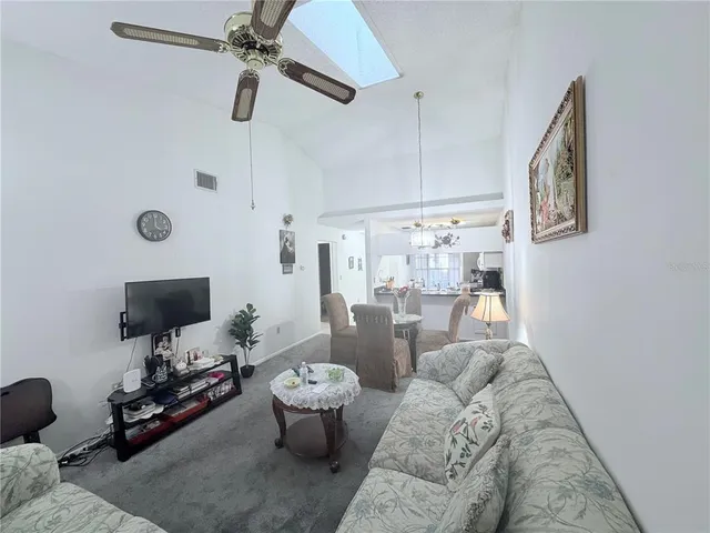 a living room with furniture a flat screen tv and a window