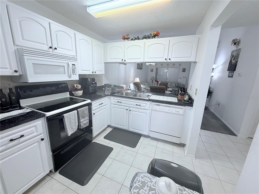 4523 Glen Hollow New Port Richey, FL 34653 - Photo 15 of 62 a kitchen with white cabinets and white appliances