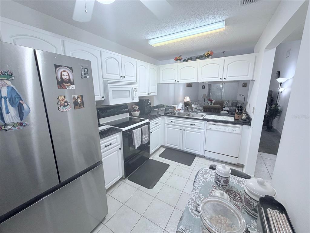 4523 Glen Hollow New Port Richey, FL 34653 - Photo 18 of 62 a kitchen with white cabinets sink and white appliances
