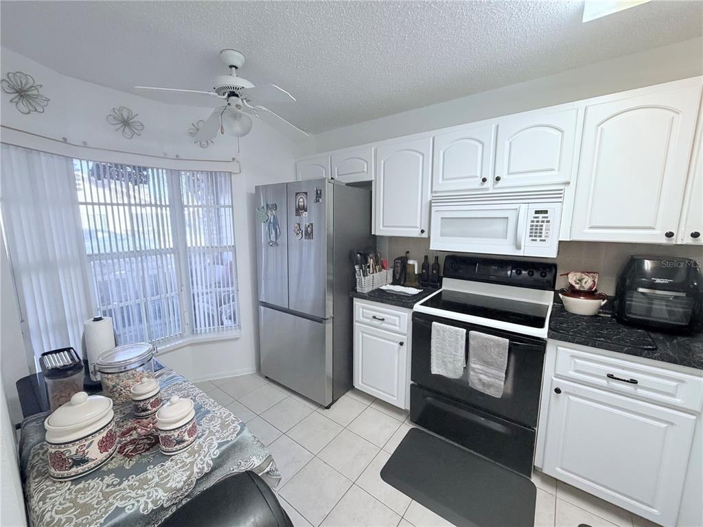 4523 Glen Hollow New Port Richey, FL 34653 - Photo 21 of 62 a kitchen with a refrigerator and white cabinets