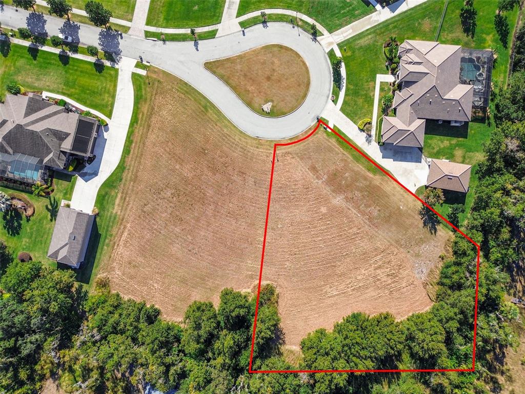 an aerial view of a house with swimming pool and outdoor seating