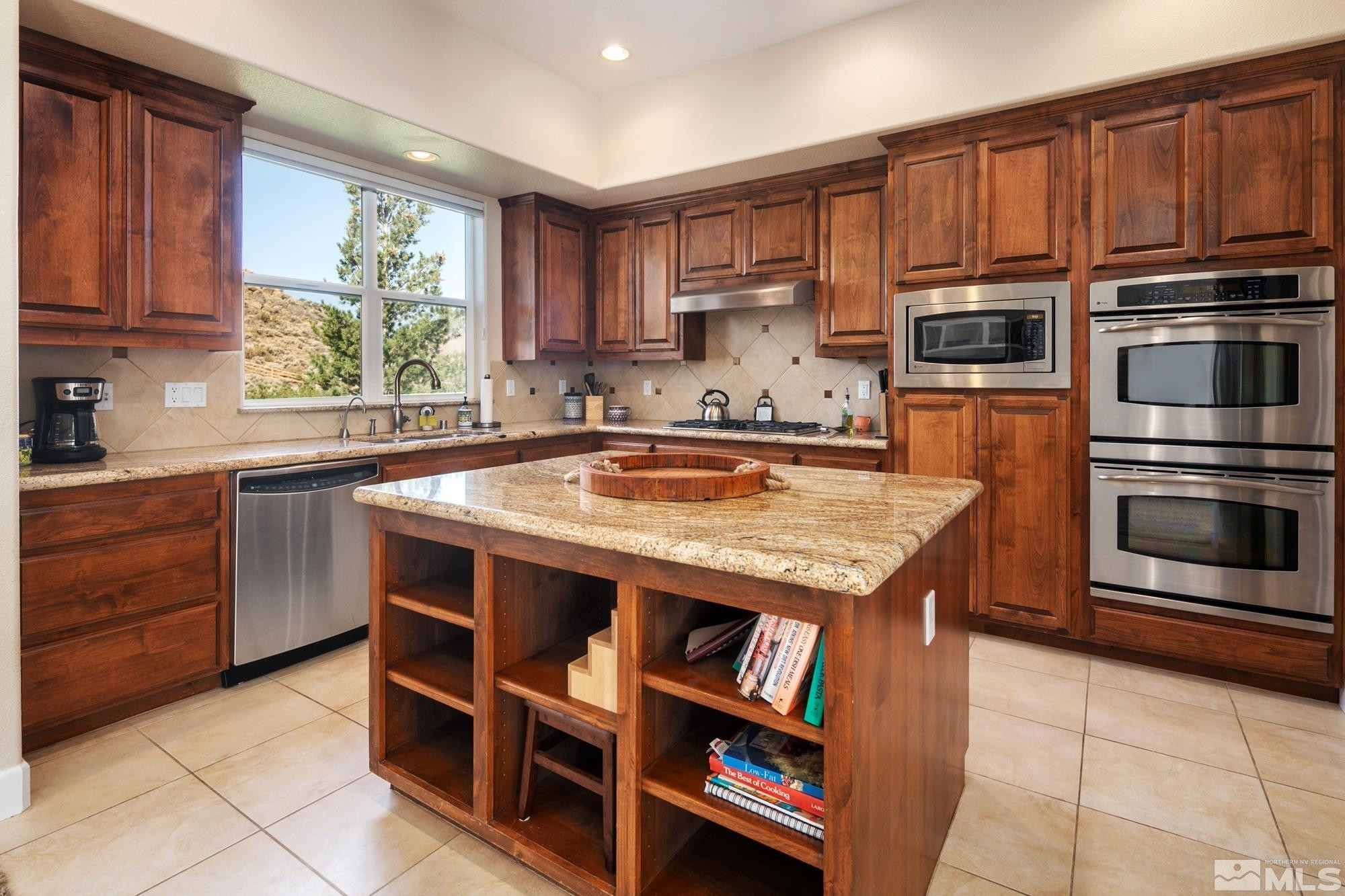 8573 Timaru Trail Reno, NV 89523 - Photo 15 of 40 a kitchen with kitchen island granite countertop a stove top oven a sink dishwasher and cabinets with wooden floor