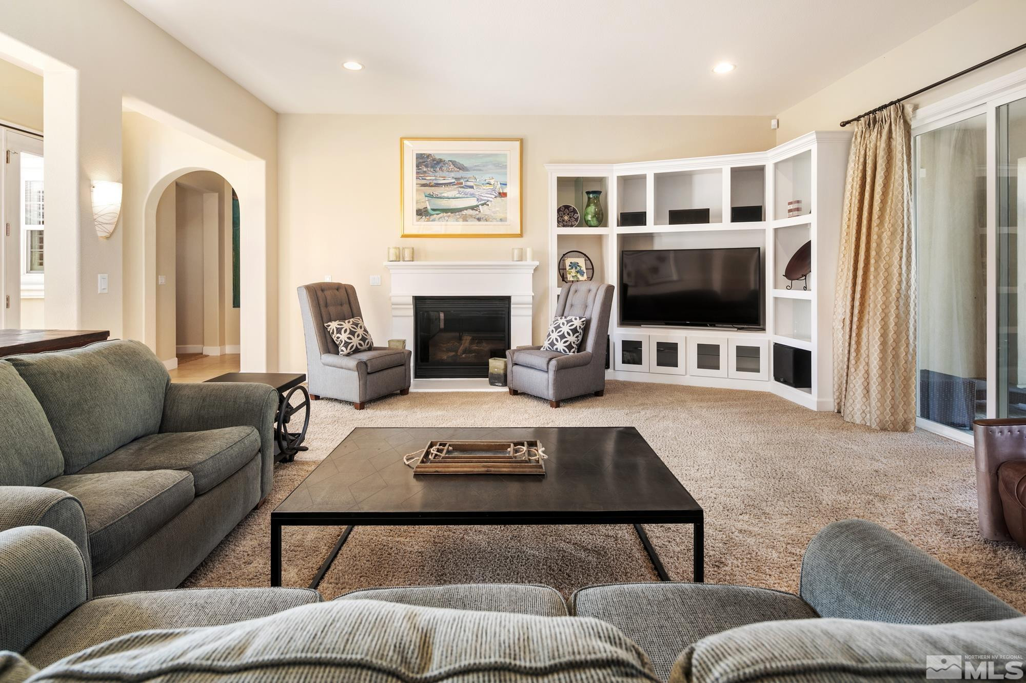 8573 Timaru Trail Reno, NV 89523 - Photo 8 of 40 a living room with furniture a fireplace and a flat screen tv