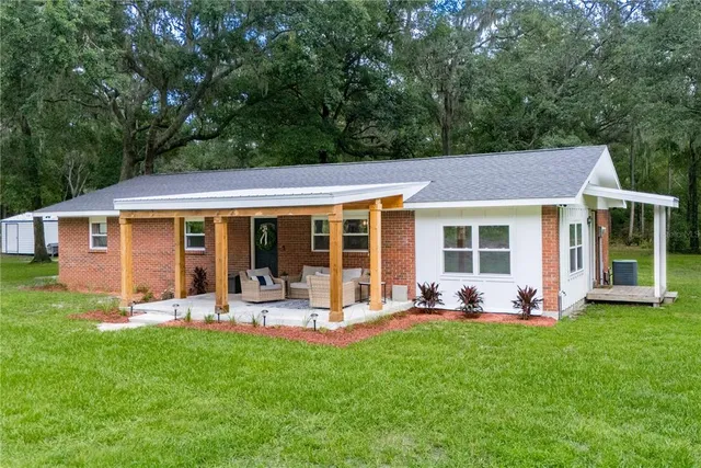 a view of a house with backyard sitting area and garden