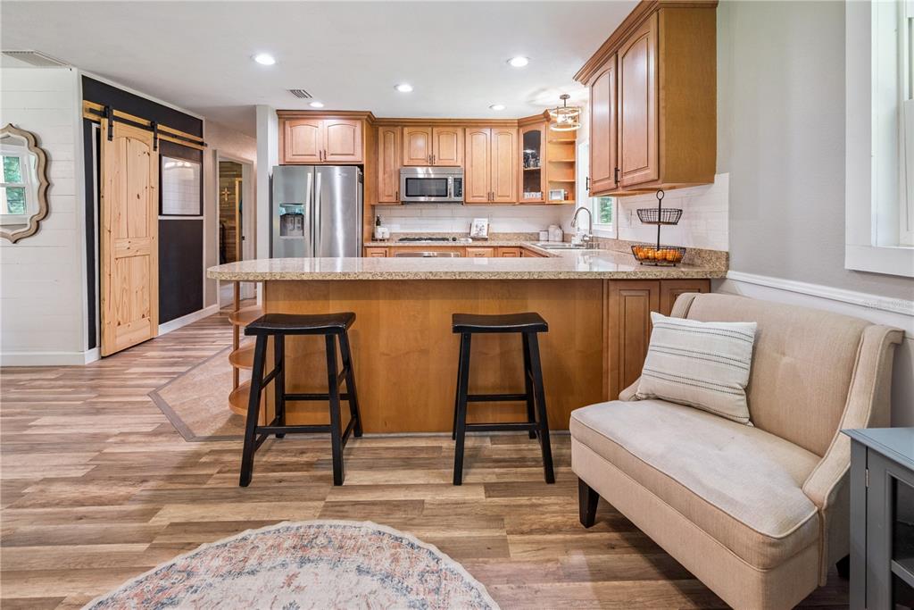 14545 Southwest 155th Avenue Brooker, FL 32622 - Photo 14 of 44 a kitchen with stainless steel appliances kitchen island granite countertop a sink and a refrigerator