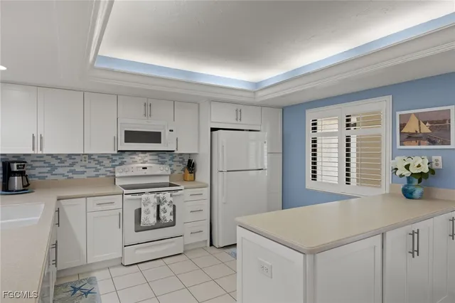 a kitchen with white cabinets sink and white appliances