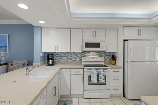 a kitchen with white cabinets and white appliances