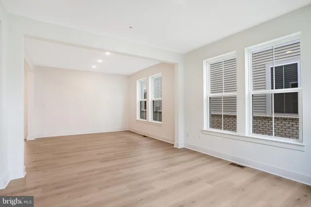 an empty room with windows and fireplace
