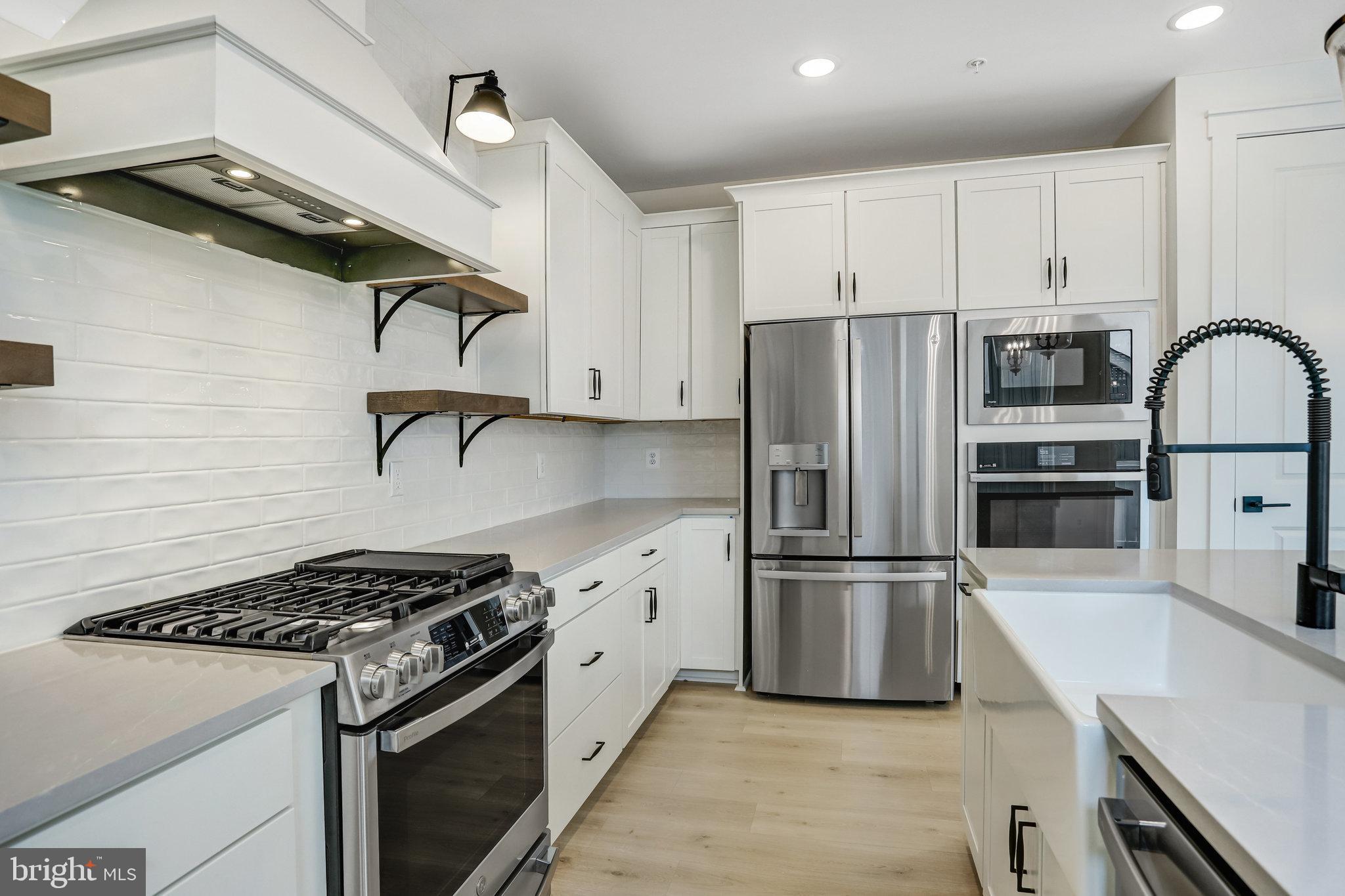 2734 Tuscarora Road Adamstown, MD 21710 - Photo 39 of 85 a kitchen with stainless steel appliances granite countertop a stove a refrigerator and a sink