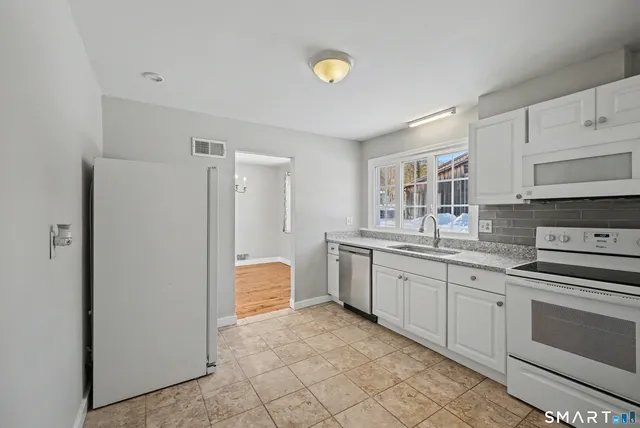 a kitchen with stainless steel appliances granite countertop a refrigerator and a stove top oven