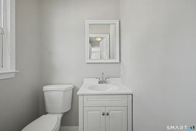a bathroom with a toilet sink and mirror