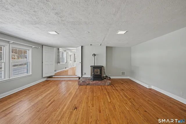 a view of empty room with wooden floor and fireplace