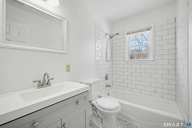 a bathroom with a sink mirror toilet and bathtub