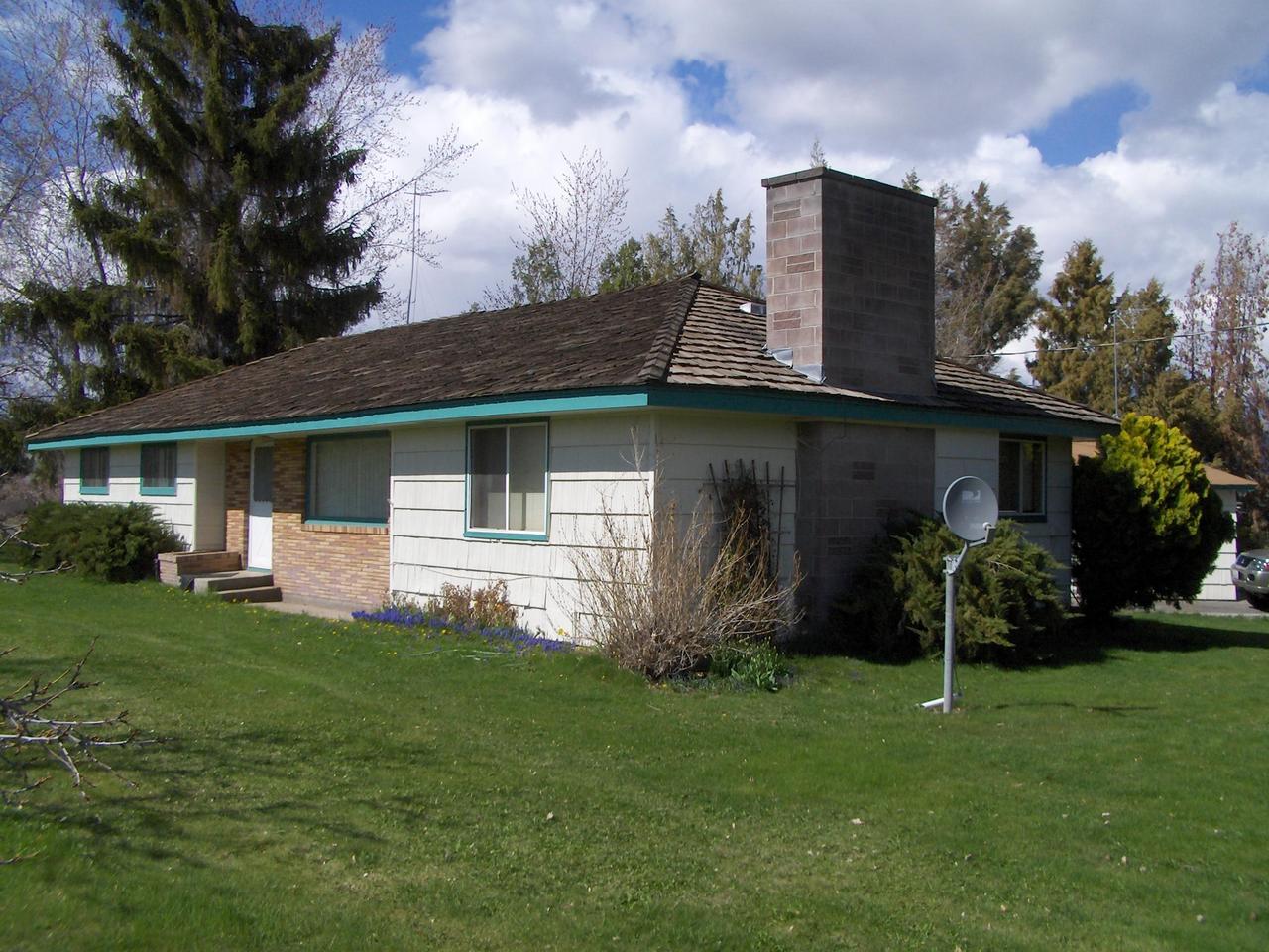 a front view of a house with a garden and plants