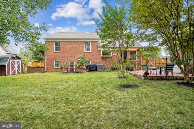 a view of a house with backyard and a tree