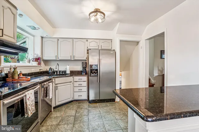 a kitchen with stainless steel appliances granite countertop a stove a sink and a refrigerator