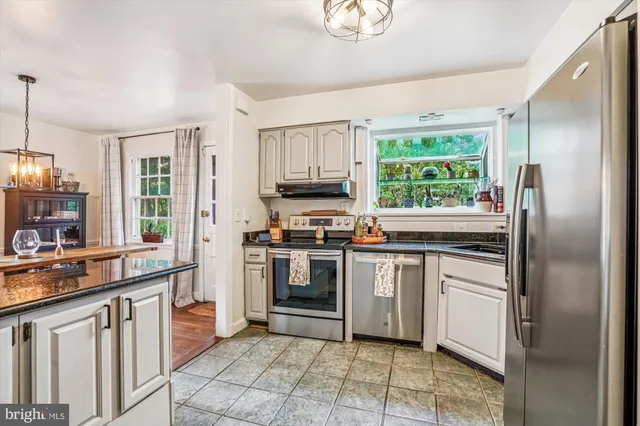 a kitchen with stainless steel appliances granite countertop a stove a sink and a refrigerator