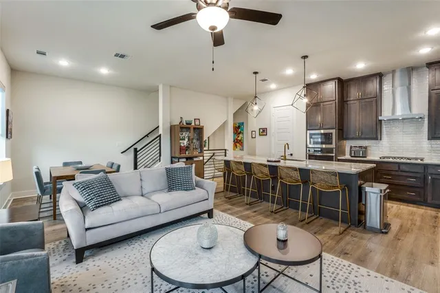 a living room with furniture kitchen view and a chandelier
