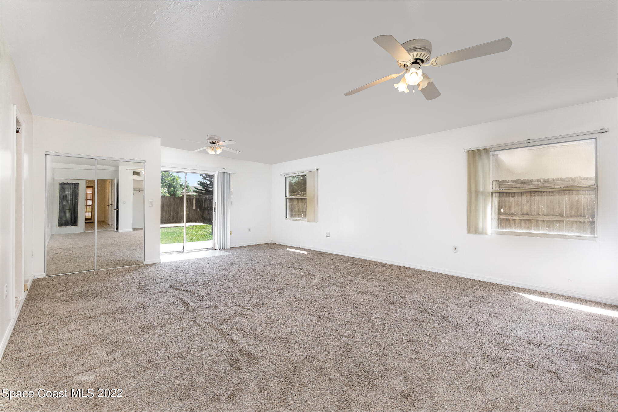 201 Orchid Boulevard Melbourne, FL 32901 - Photo 23 of 36 a view of an empty room with chandelier fan and fire place
